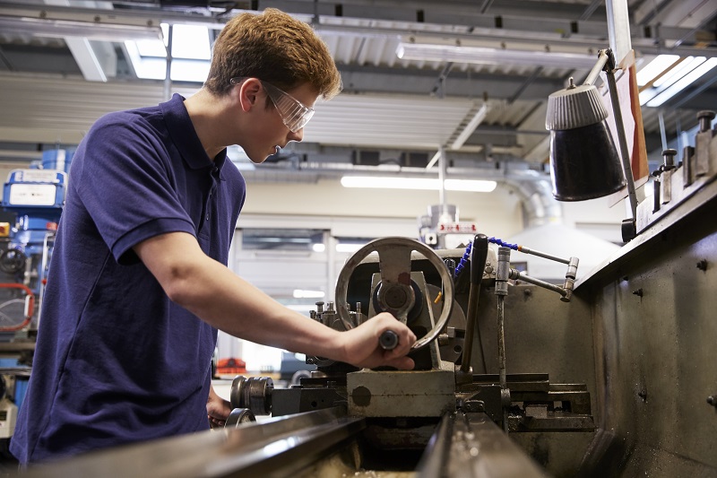 Male Teenage Apprentice In Engineering Factory Using Lathe trainer