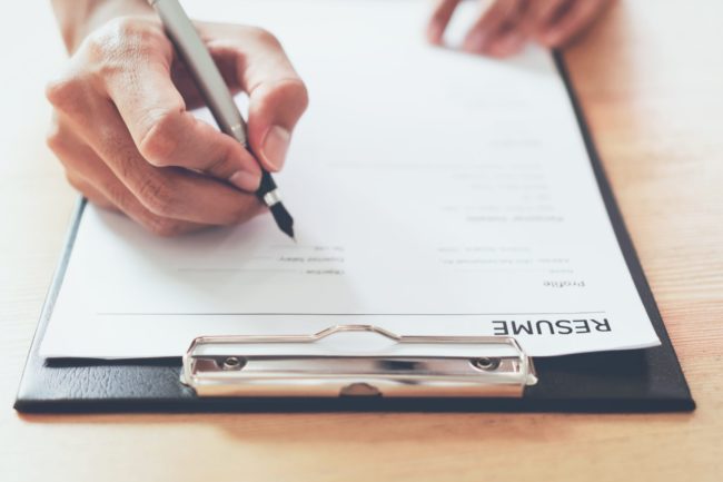 man submit resume to employer to review job application. The concept presents the ability for the company to agree with the position of the job.